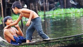 Iconic Tonle Sap floating homes in Cambodia for a Tonle Sap Tours banner with Legend Travel Group.